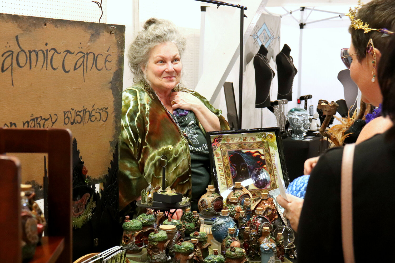 Catherine Jabusch talks to a potential customer at a booth for her business, The Woodland Wandolier, at the Southwest Washington Fairgrounds in Chehalis during the Centralia Fantasy Festival on Saturday, May 27.