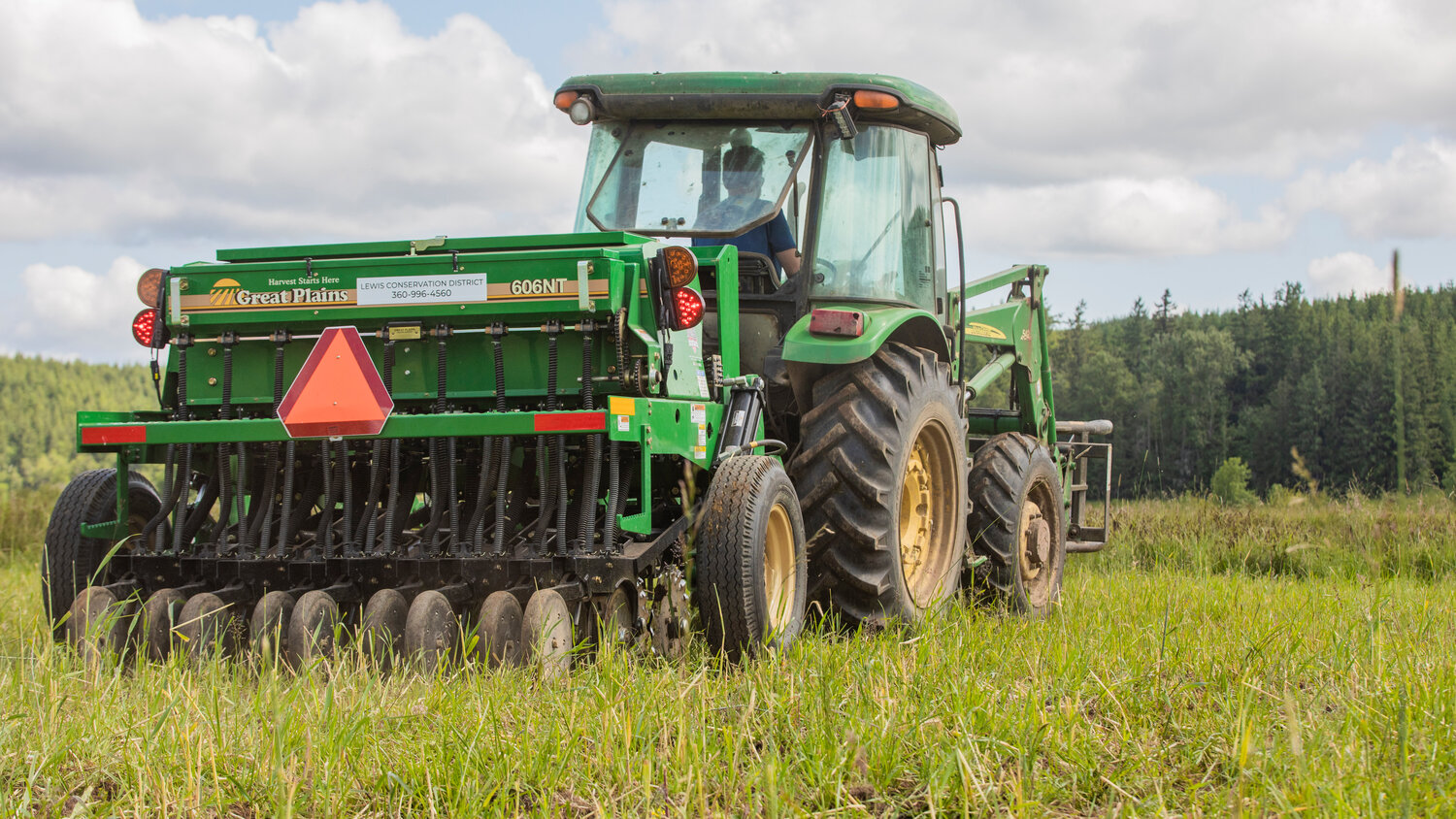 Fourth-generation dairy farmer Jack Mallonee, 22, drives a tractor pulling a no-till seed driller through a field off Wildwood Road in Curtis on Thursday, June 1.