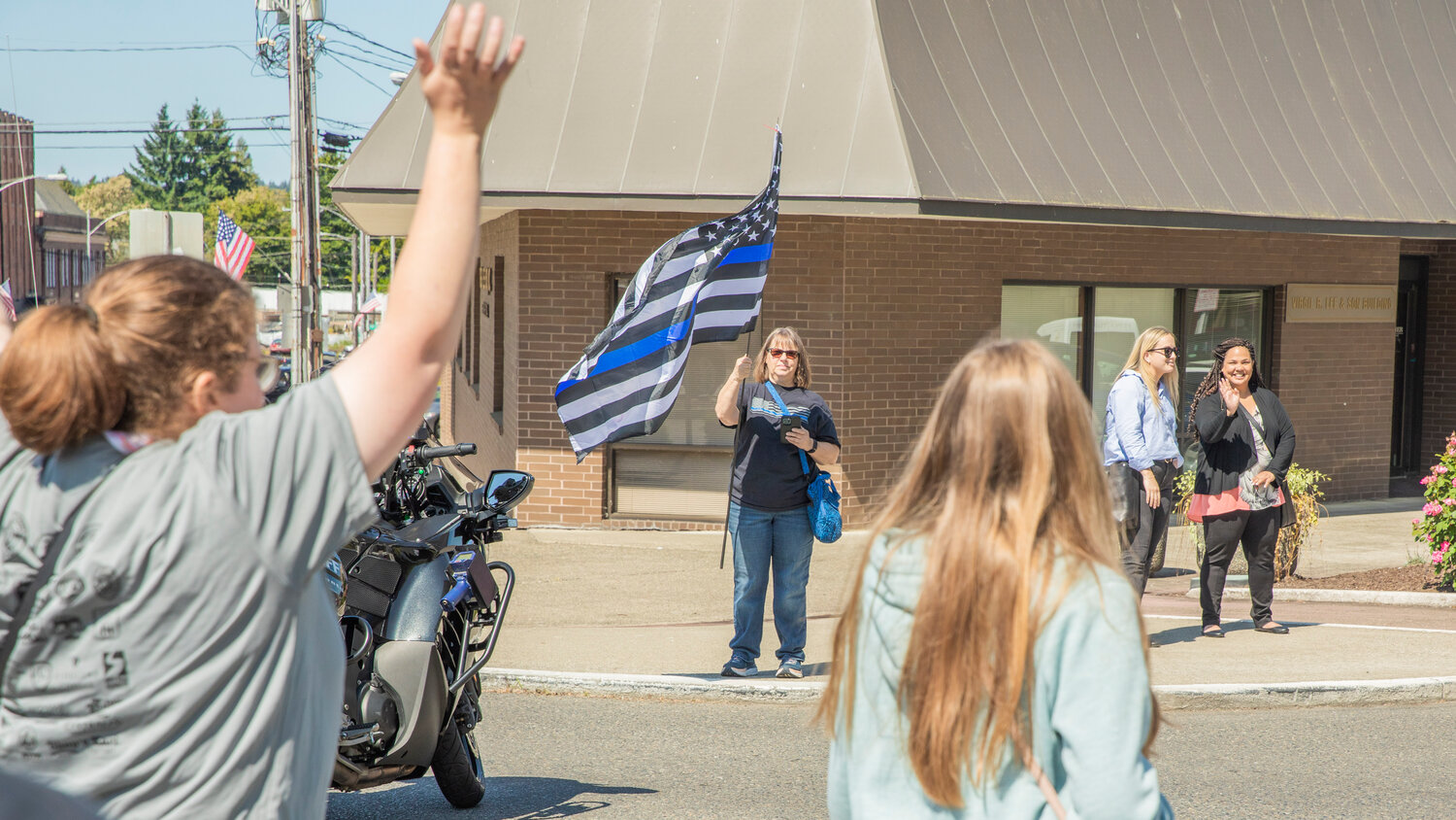 Supporters wave flags and cheer for participants in the Lewis County Special Olympics Law Enforcement Torch Run in downtown Chehalis on Friday, June 2.