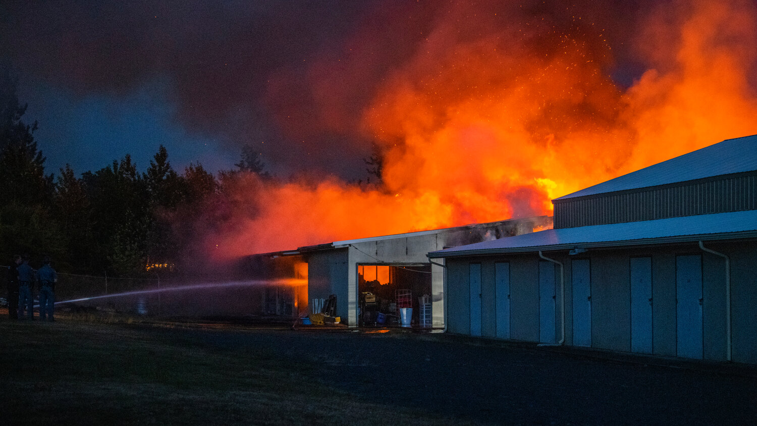 A column of smoke and flames rises from a structure in the 100 Block of Alder Avenue Northwest in Napavine as firefighters and Washington State Patrol respond to the scene on Saturday, June 3.