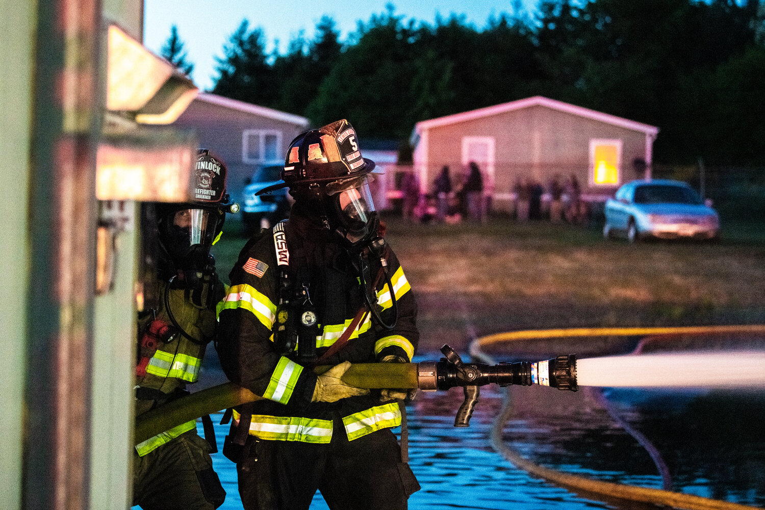 Lewis County Fire District 5 and Winlock firefighters operate a hose while controlling flames in a structure near the 100 Block of Alder Avenue Northwest in Napavine on Saturday, June 3.