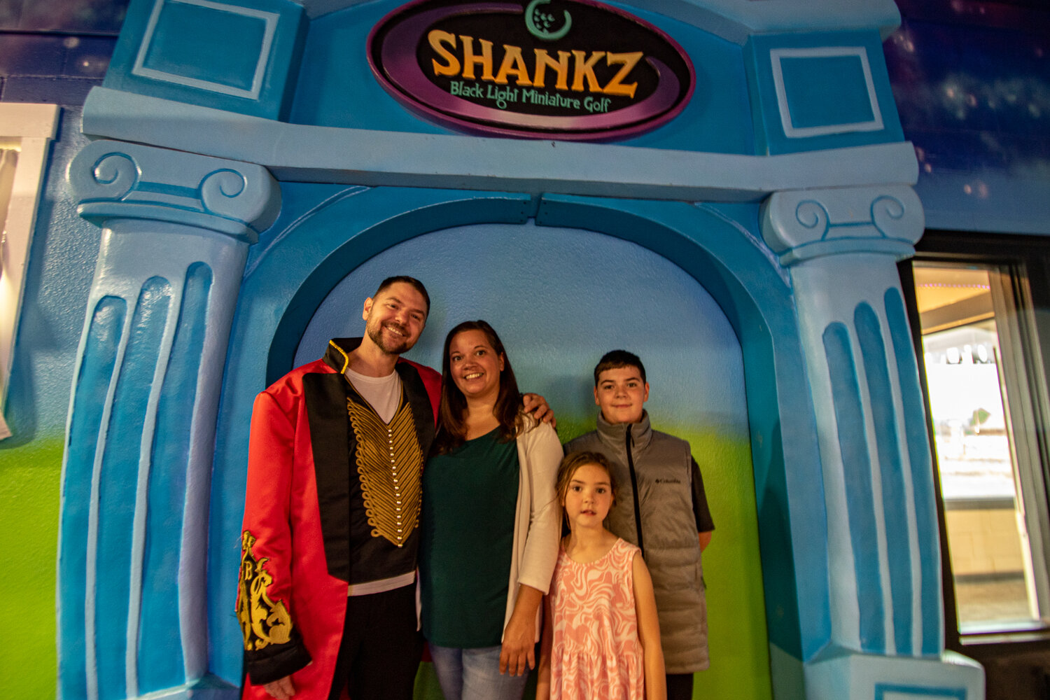 Guy Steele, who performs as Mr. Twister, poses with his wife, Tessa, son, Guy Jr., and daughter, Shiloh, at their newly reopened family business, Shankz Black Light Miniature Golf, on Thursday, Aug. 31.