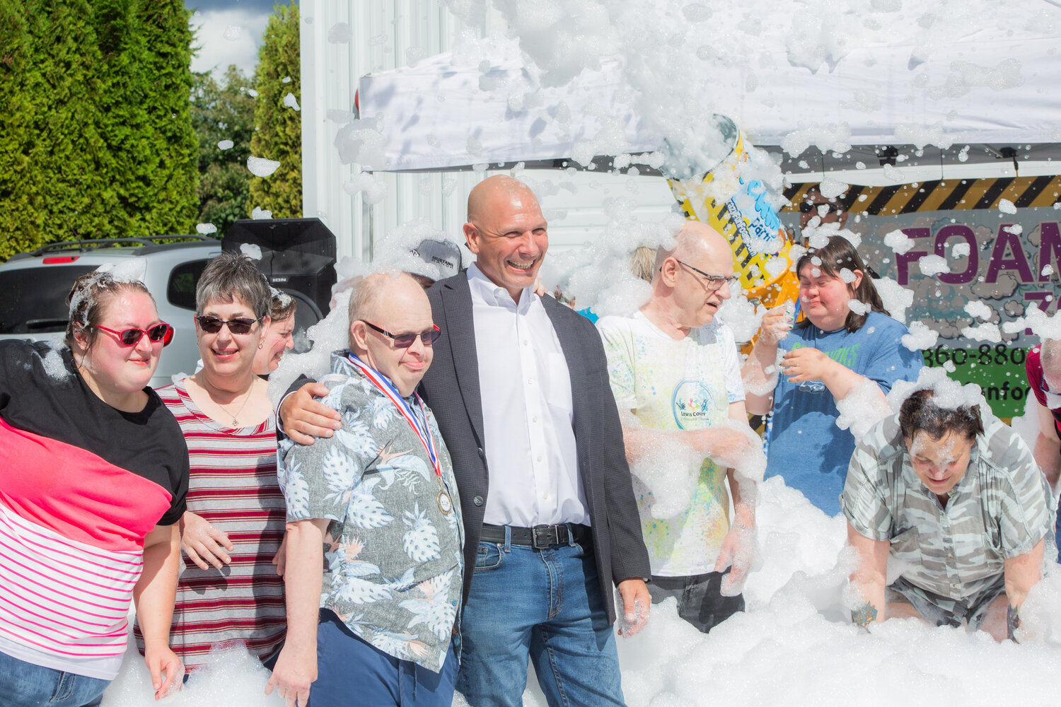 Rep. Peter Abbarno, center, poses with members of Lewis County Accessible Recreation during a celebratory foam party. The group, which provides recreational opportunities for people with disabilities, recently celebrated it's first year in operation.