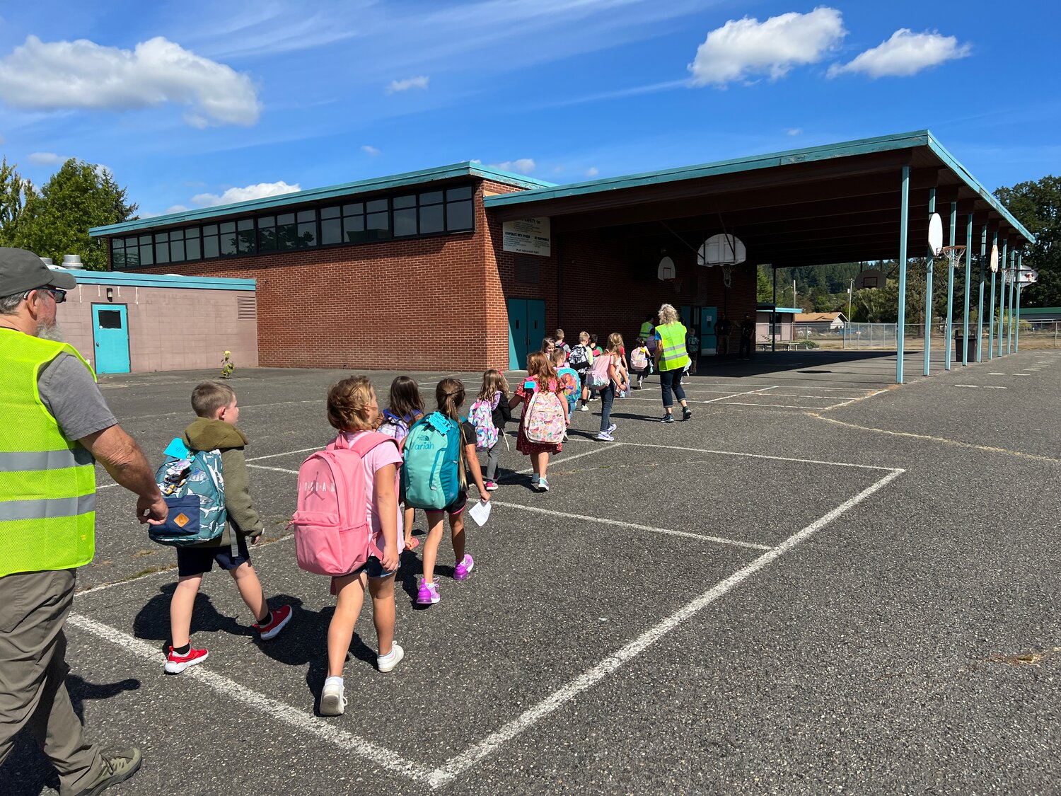Students are walked into Olympic School by volunteers for the Bethel After-School Program, which launched Sept. 13, provides games, art, conversation and other activities from 12:30-4 p.m. every Wednesday. (Photo: Brian Mittge)