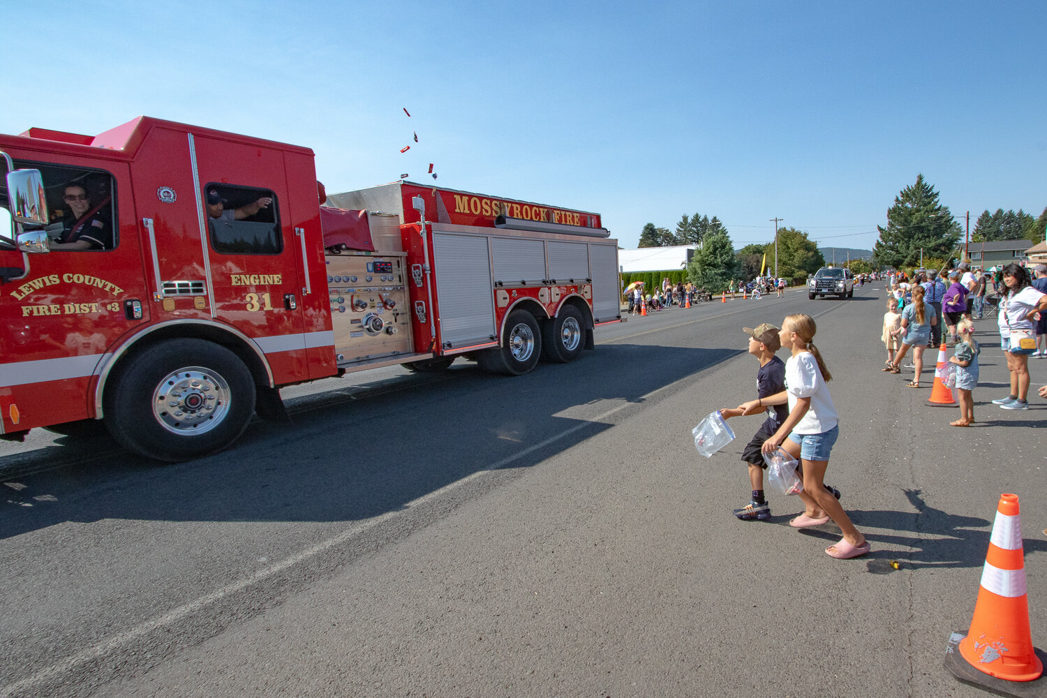 Firefighters from Lewis County Fire District 3 toss candy out to parade-goers on Saturday, Sept. 16, during the Mexican Independence Day celebration in Mossyrock.