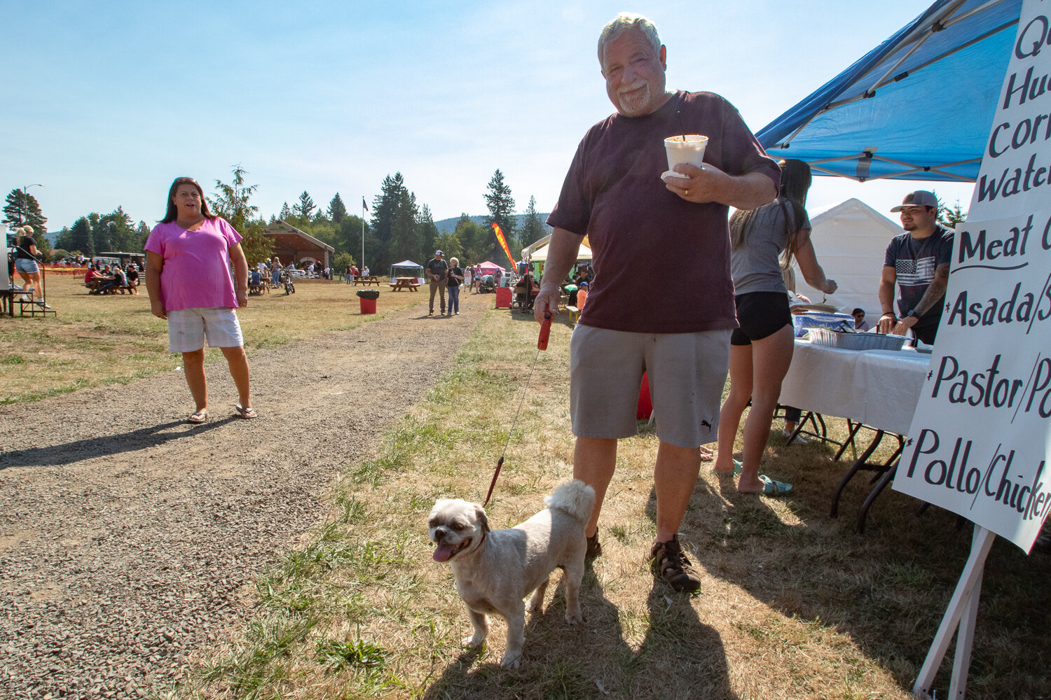 Kevin Drake of Silver Creek enjoys a cup of elote and gets ready to order some tacos with his dog, Briggs, on Saturday, Sept. 16 at Klickitat Prairie Park in Mossyrock during the Mexican Independence Day celebration.