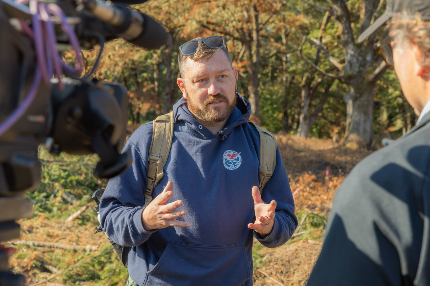 Certified Burner Program Manager Kyle Lapham, with the Department of Natural Resources, is interviewed by members of the media while leading a training on prescribed burning at West Rocky Prairie near Tenino on Thursday, Sept. 21.