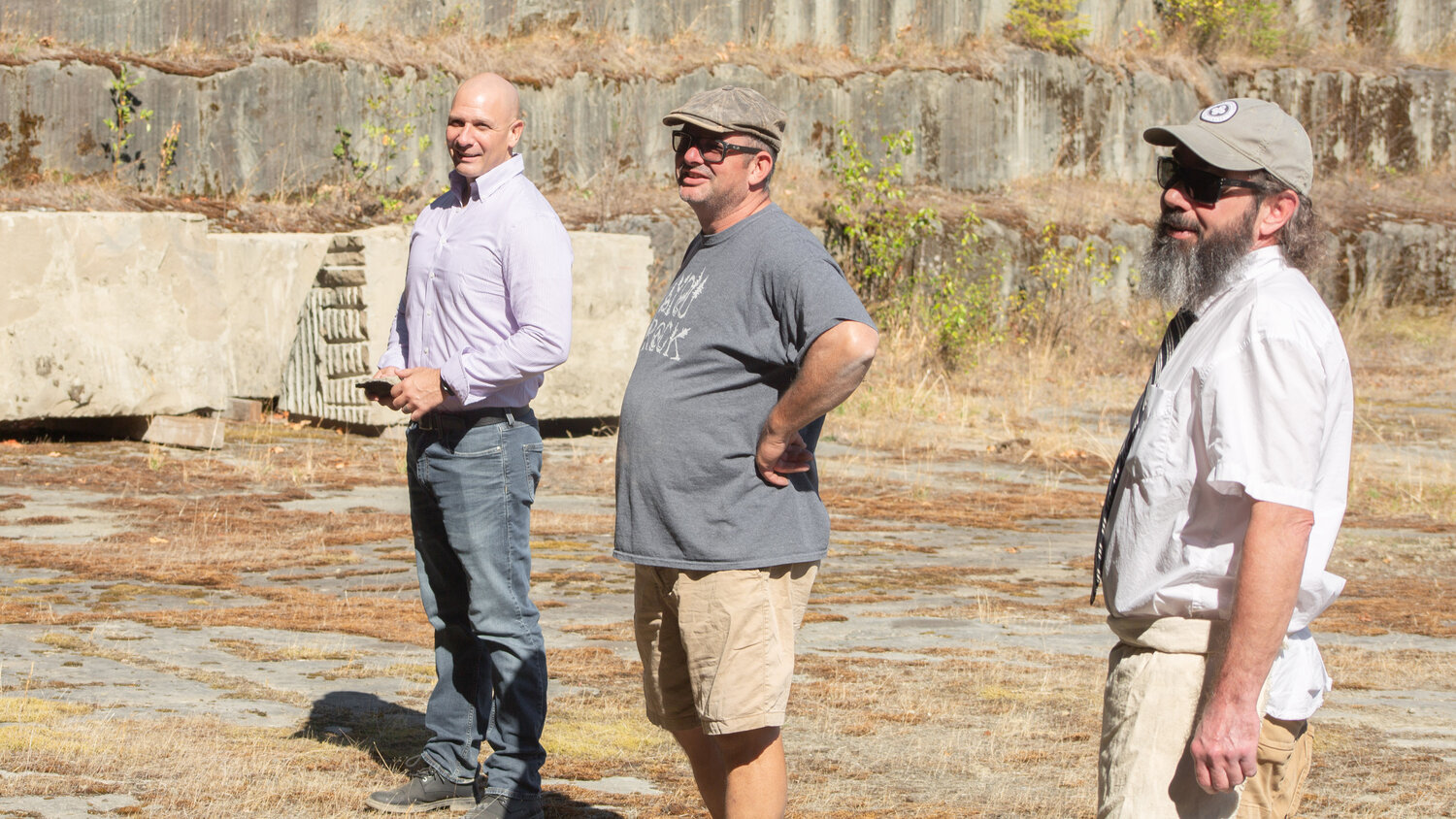 Rep. Peter Abbarno, left, stands next to Dan Miller and Bill Lenker in the old Hercules Quarry in Tenino on Friday.