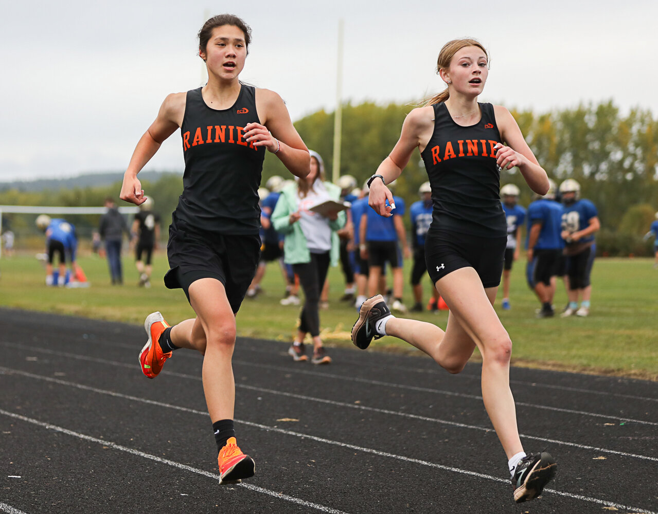 Angelica Askey (left) and Rayanna Wisner (right) come into the chute neck-and-neck in the girls race at a 2B cross country meet in Adna on Sept. 28. Wisner beat Askey by two-tenths of a second, but the two ended up finishing second and third, behind teammate Madison Ingram, who ran with the boys and finished a minute and-a-half faster in the boys' race.