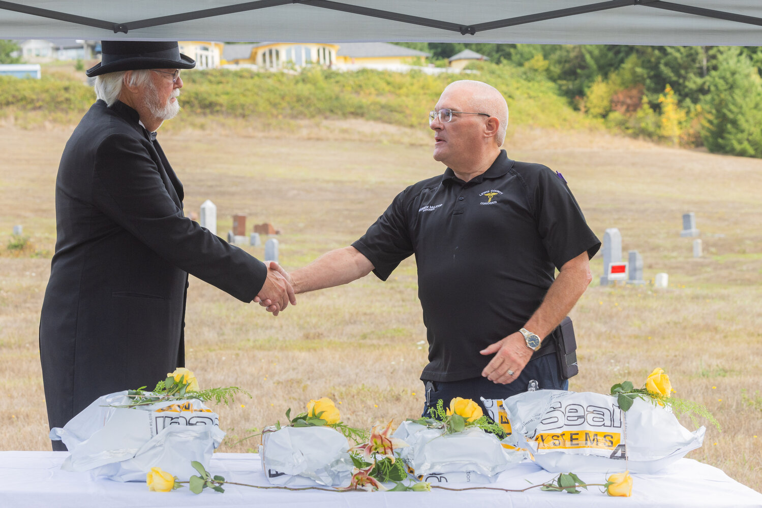John Panesko, left, shakes hands with Lewis County Coroner Warren McLeod during a ceremony in Chehalis honoring unclaimed remains on Thursday, Sept. 28.