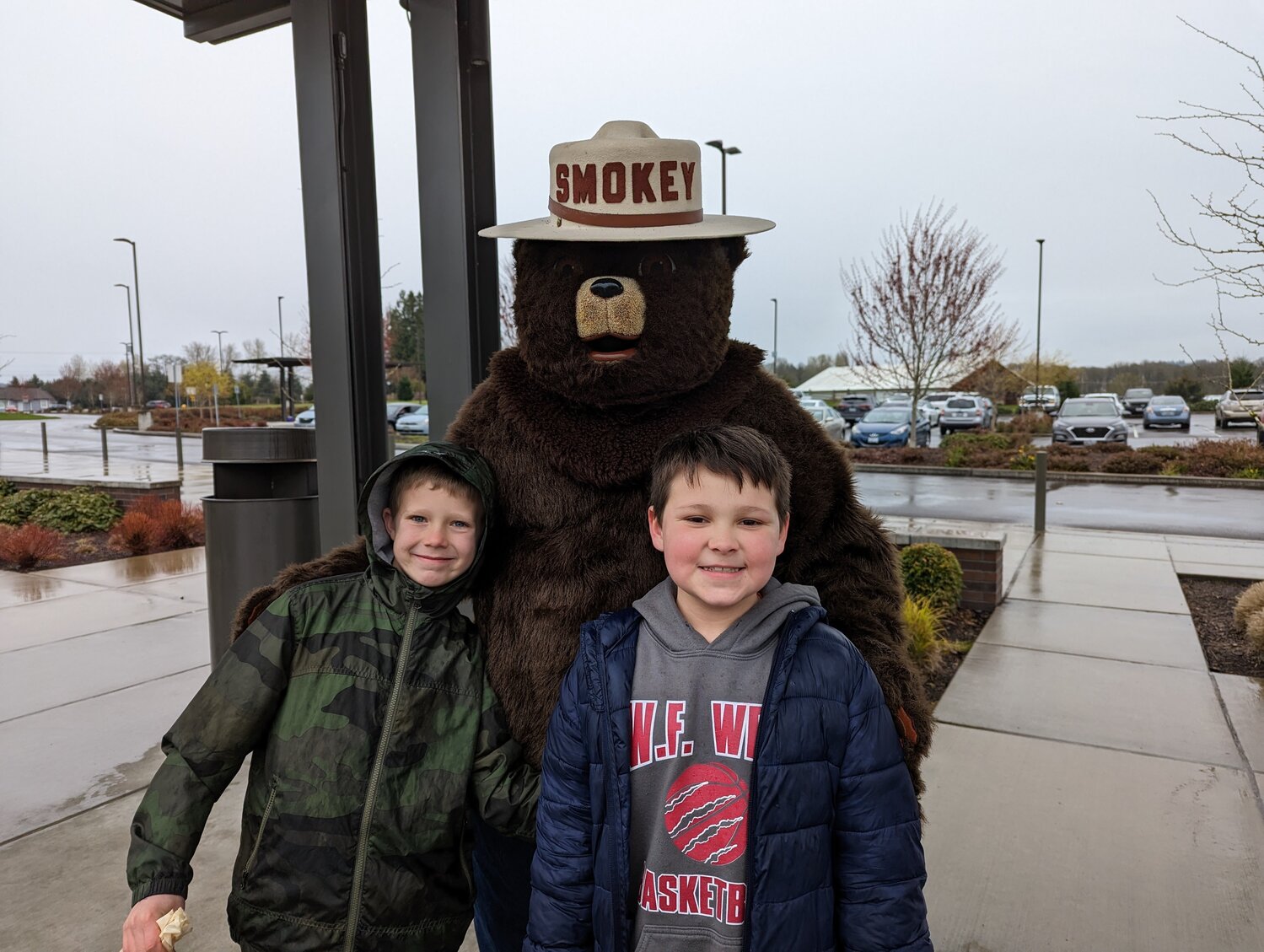 Students smile for a photo with Smokey Bear outside Orin C. Smith Elementary in Chehalis.