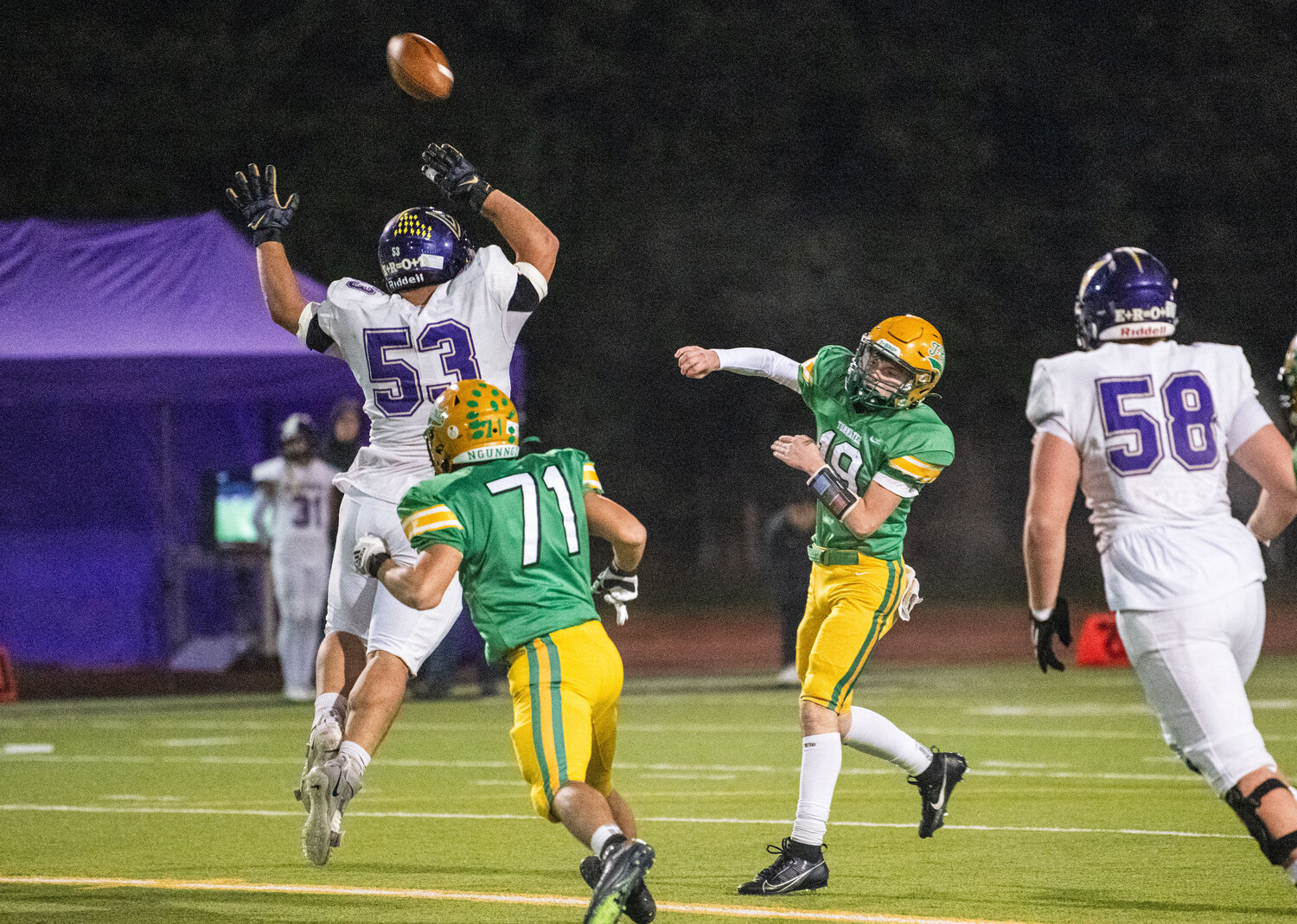 Tumwater quarterback Ethan Kastner (19) lofts a pass over a North Kitsap defender’s head during the 2A state semifinals on Saturday.