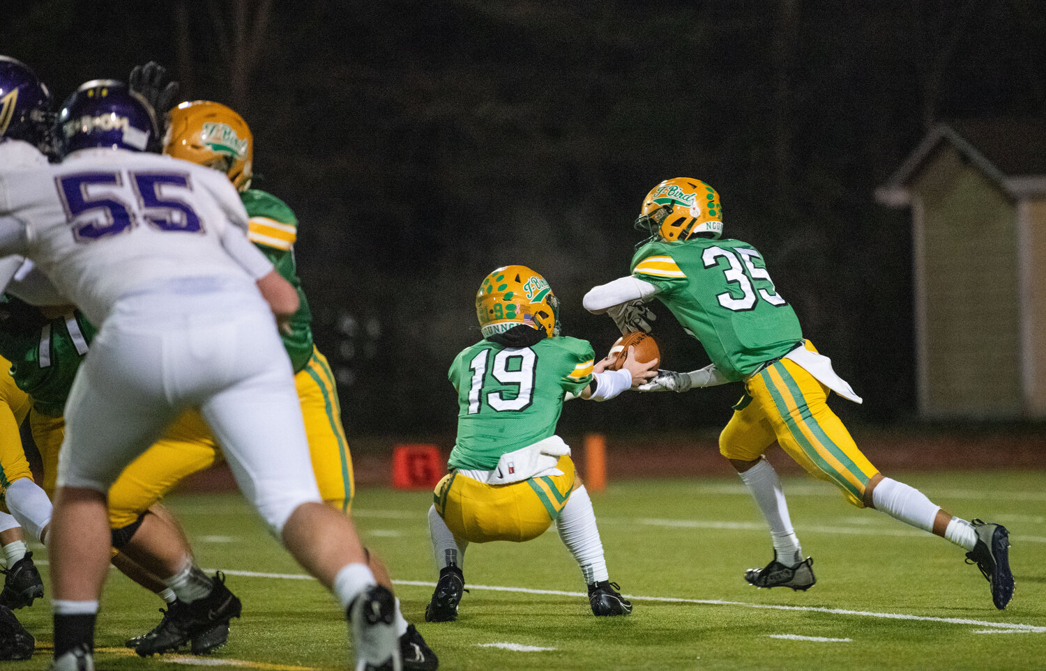 Tumwater quarterback Ethan Kastner (19) hands the football off to Kooper Clark (35) during a 2A state semifinal game against North Kitsap on Saturday.