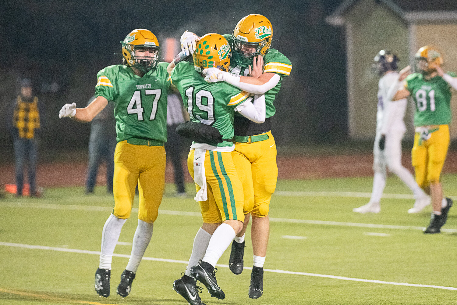 Mathias Rodriguez (47), Ethan Kastner (19) and Jacob Dillon celebrate after the final kneel-down of Tumwater's 19-17 win over North Kitsap in the 2A state semifinals on Nov. 25.
