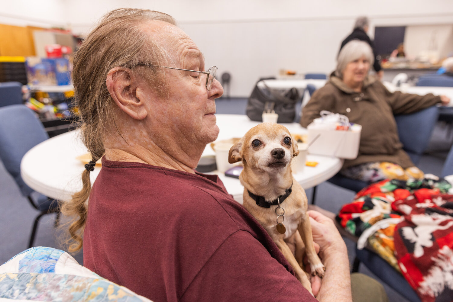 Charles Burgie, 73, smiles while holding Zeus, a Chihuahua, after he was evacuated from his residence at the Centralia Manor Apartments following a fire on Wednesday, Nov. 29.