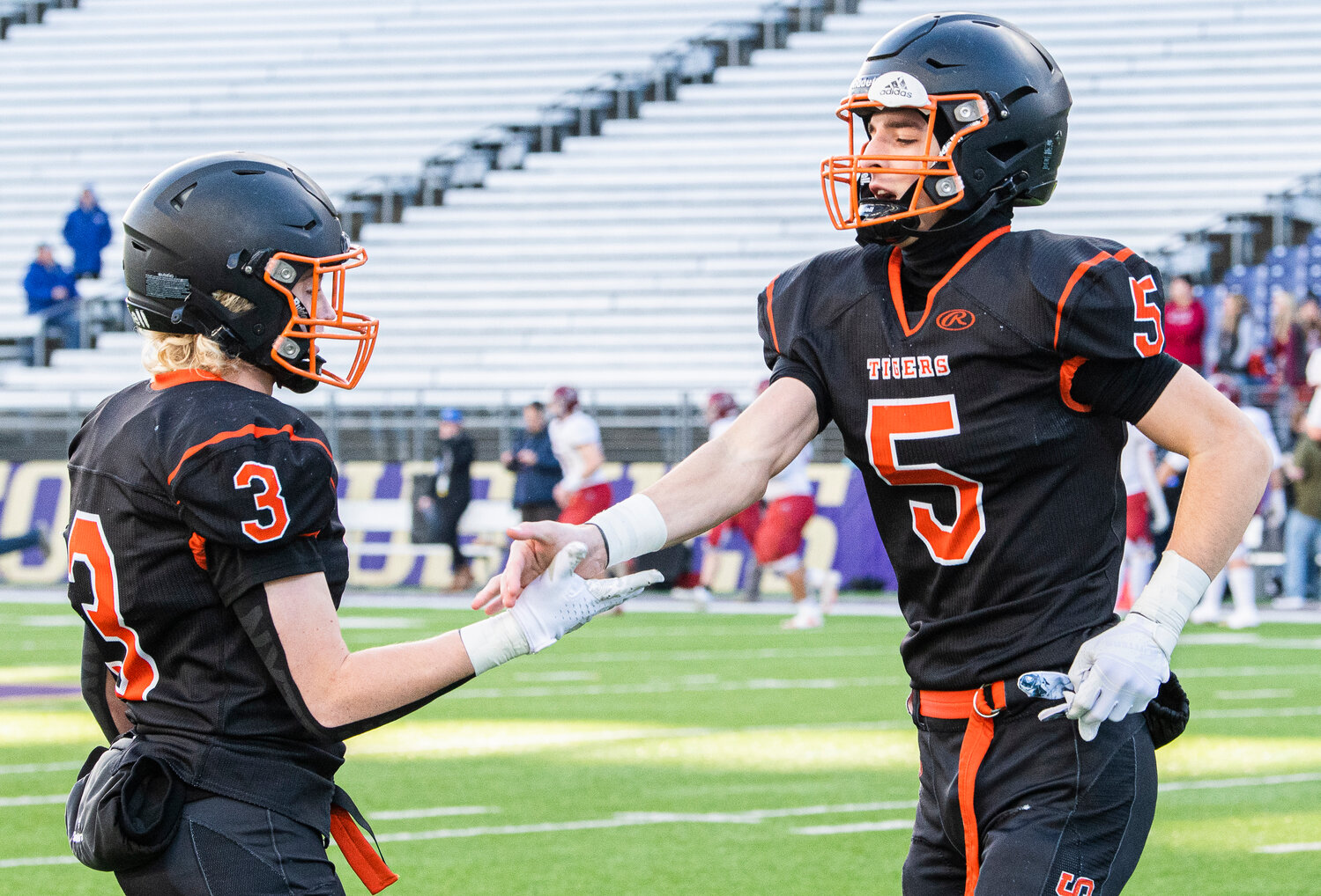 Napavine’s Karsen Denault (5) high-fives Beckett Landram (3) in the 2B State Championship game against Okanogan at Husky Stadium on Saturday, Dec. 2. The matchup is Denault’s first time on the football field since breaking his collarbone five weeks ago.