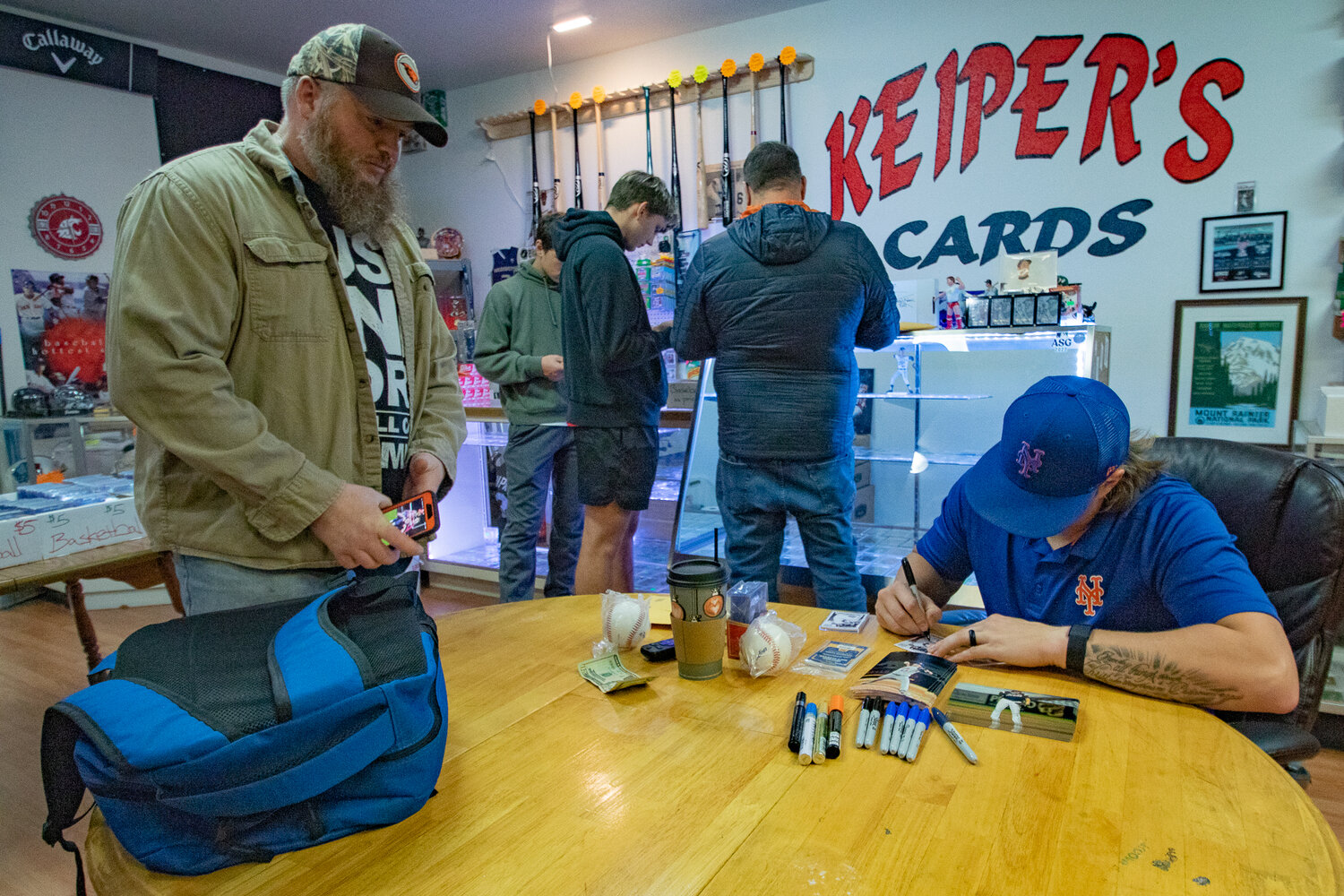 New York Mets prospect and W.F. West High School pitching star Dakota Hawkins signs an autograph for a local fan during at Keiper's Cards on Saturday, Dec. 2, during a card and memorabilia show in downtown Centralia.