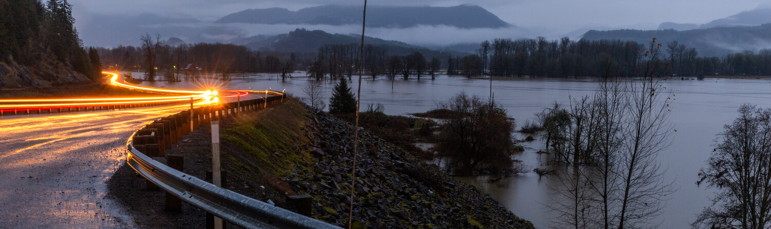 Vehicles drive along Highway 12 in Randle as water from the Cowlitz River floods portions of the Big Bottom valley on Wednesday, Dec. 6.