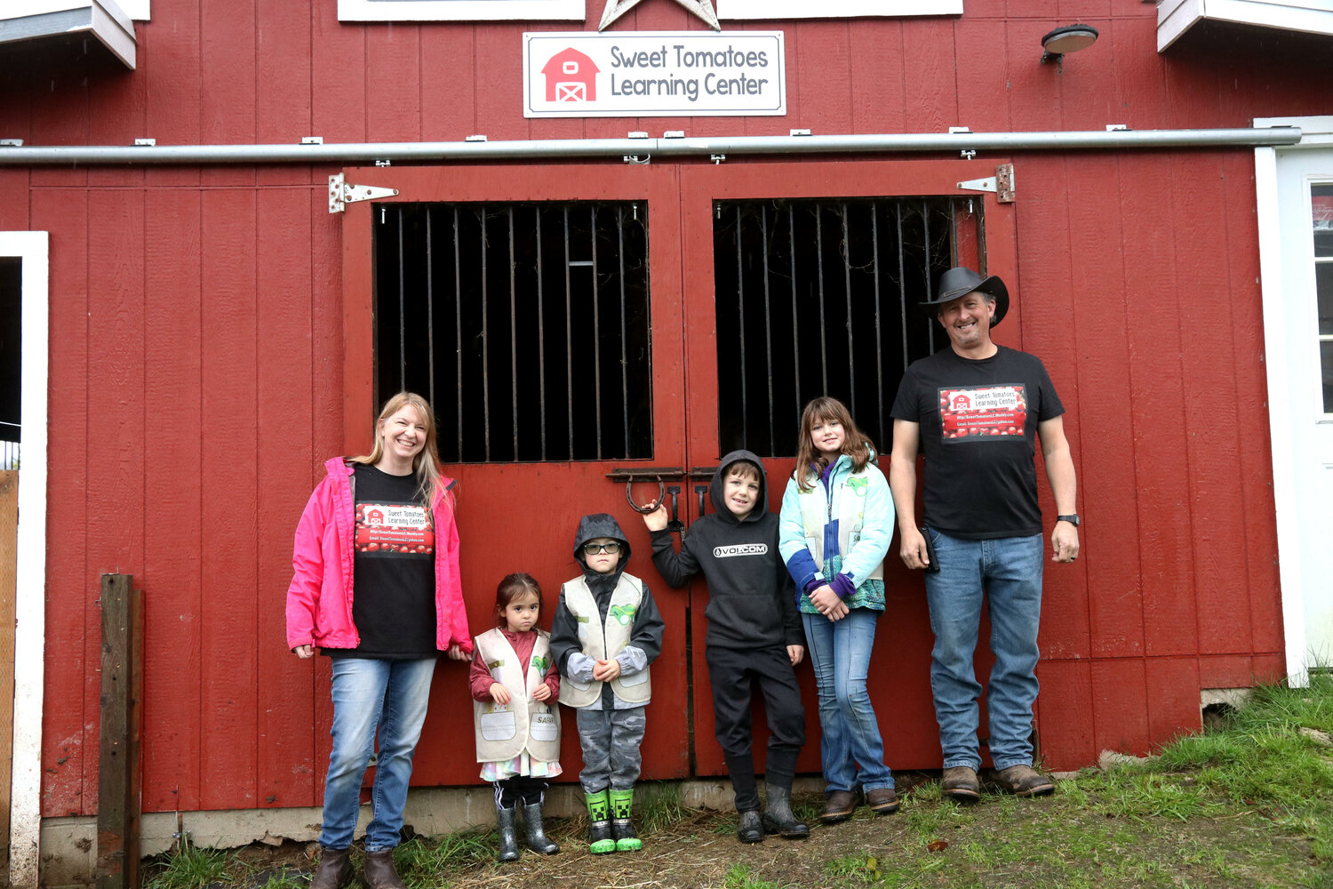 Sweet Tomatoes Learning Center Executive Director Kathleen Reed and her husband Tom Reed stand with students Maya, 4, Owen, 5, Camden, 7, and Lyla, 10, at the learning center in Chehalis on Wednesday, Dec. 6.