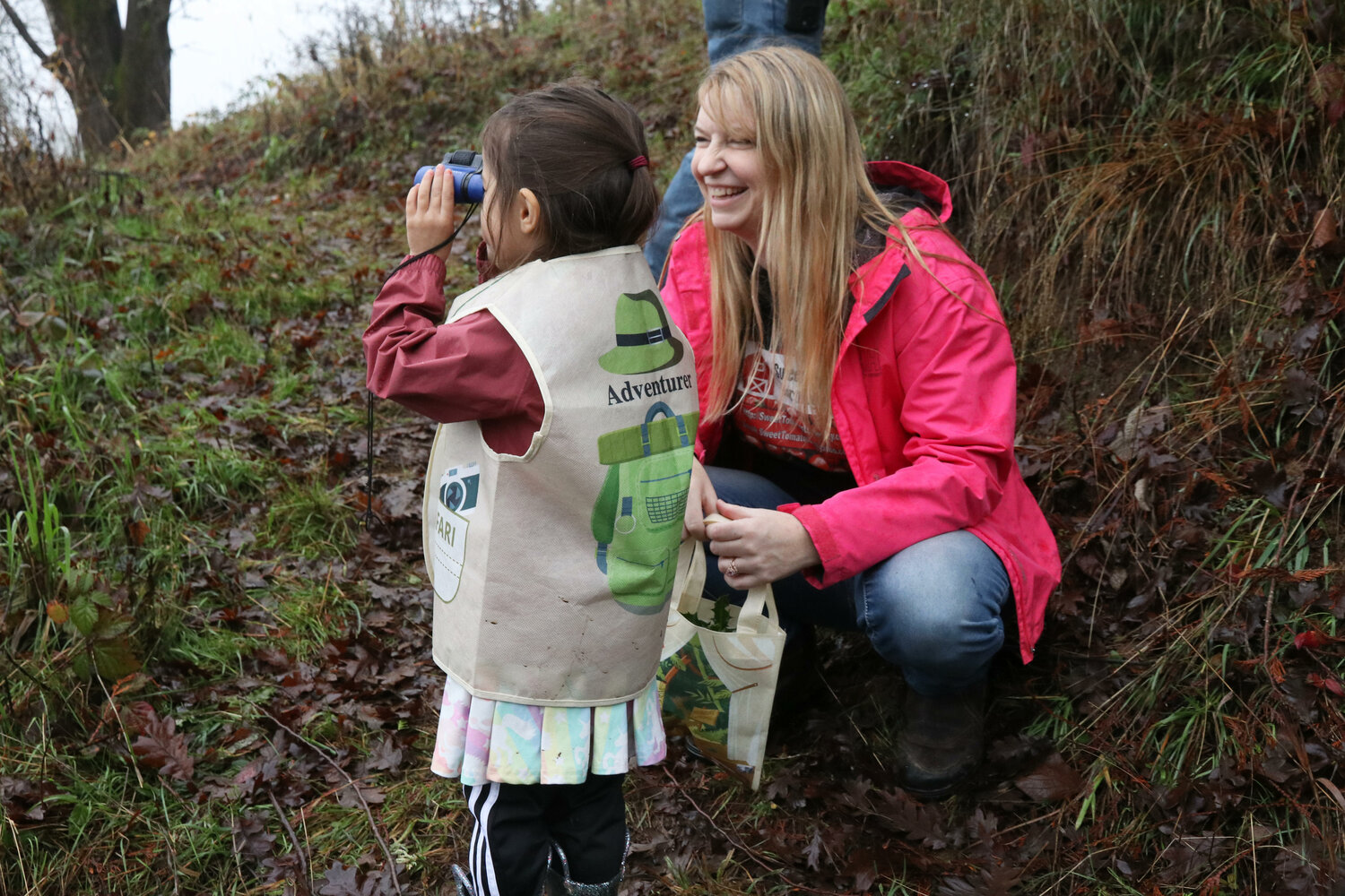 Sweet Tomatoes Learning Center Executive Director Kathleen Reed smiles while Maya, 4, looks for birds along the learning center’s nature trail in Chehalis on Wednesday, Dec. 6.