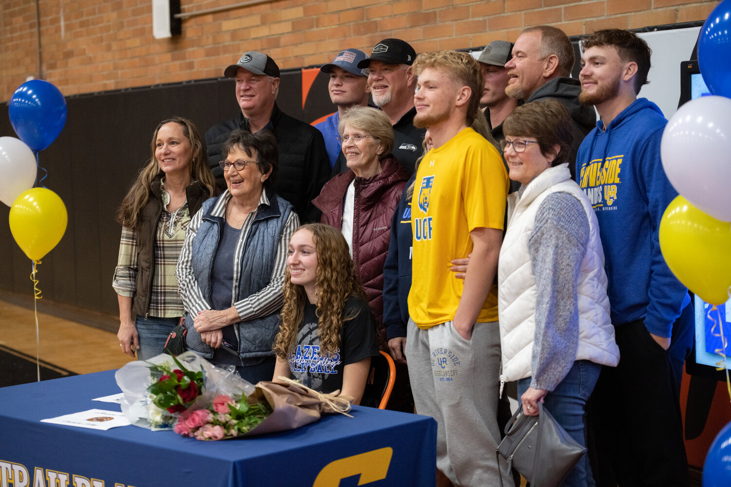 The Wasson exteded family poses for a photo after Lauren Wasson (sitting) and Von Wasson (in yellow) signed their NLIs to play volleyball at Centralia College and golf at UC Riverside, respectively, at a joint ceremony at Centralia High School on Dec. 8,